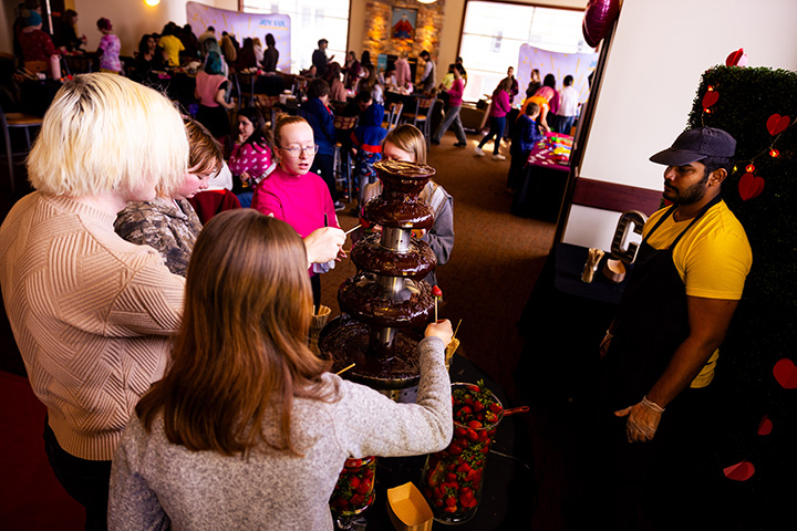 People enjoy a chocolate fountain.