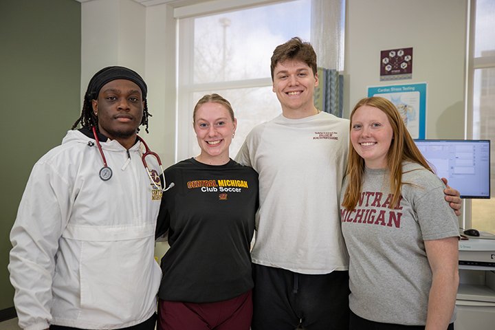 Four exercise science students pose for a photo. One of them has a stethoscope around their neck.