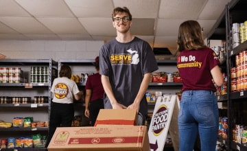 Student Matthew Thomas moves boxes of food while volunteering in the CMU Student Food Pantry