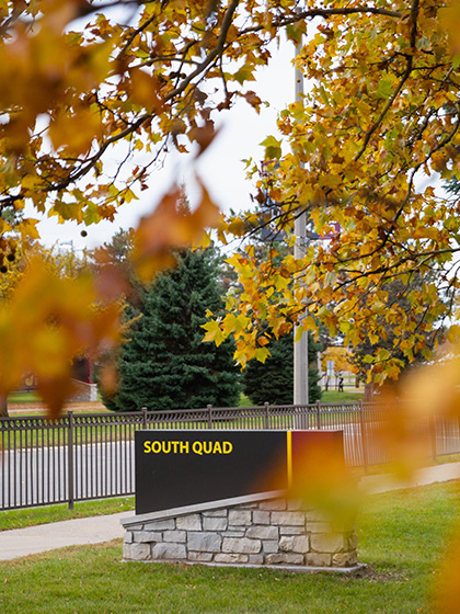 A fall scenic of a campus sign that reads 'South Quad'