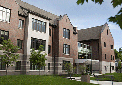 Graduate housing, brick apartments, showing the lawn and trees.