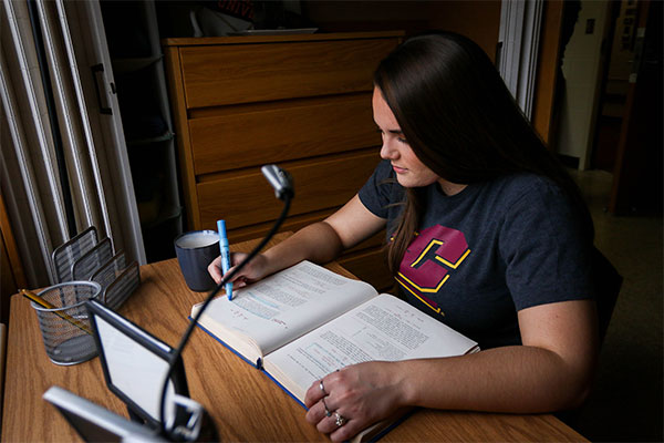 A student studying at their desk in their dorm