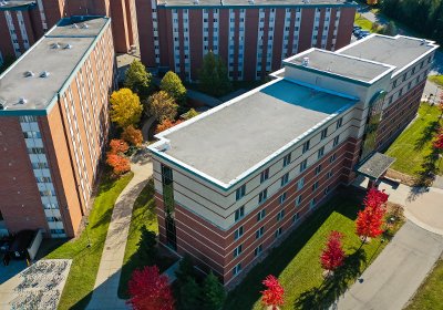 Aerial image of Wheeler hall on Central Michigan Universities campus with green grass and red trees.