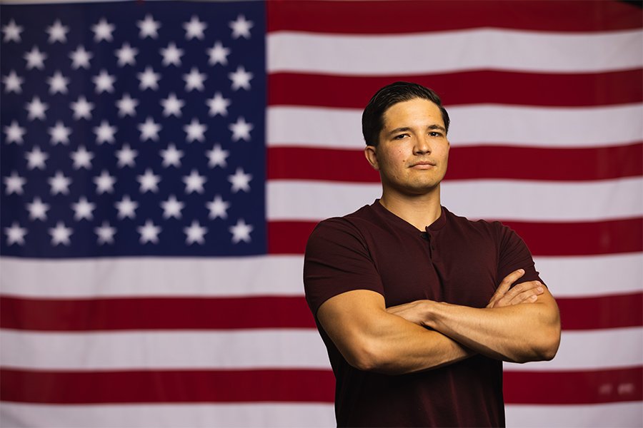 student standing by American flag