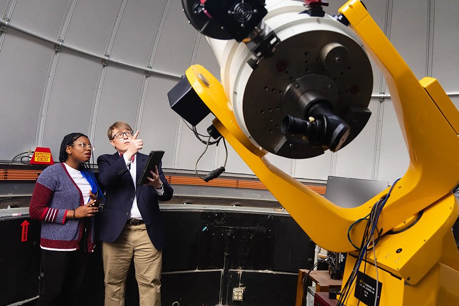 Student and professor point to large telescope in CMU's Brooks Observatory