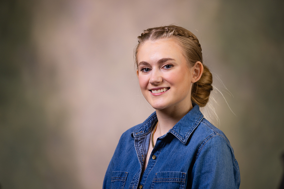 Professional headshot of Eliza Atkinson wearing a blue denim shirt while looking at the camera.