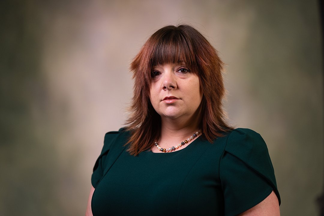 Professional headshot of Mandy Brothers wearing a green dress while looking at the camera.