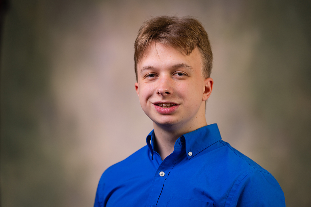 Professional headshot of Nick Green wearing a blue button-up shirt while looking at the camera.