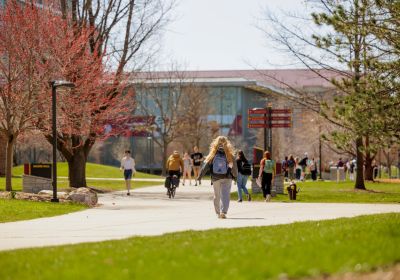 Photo of a student walking outside on campus.