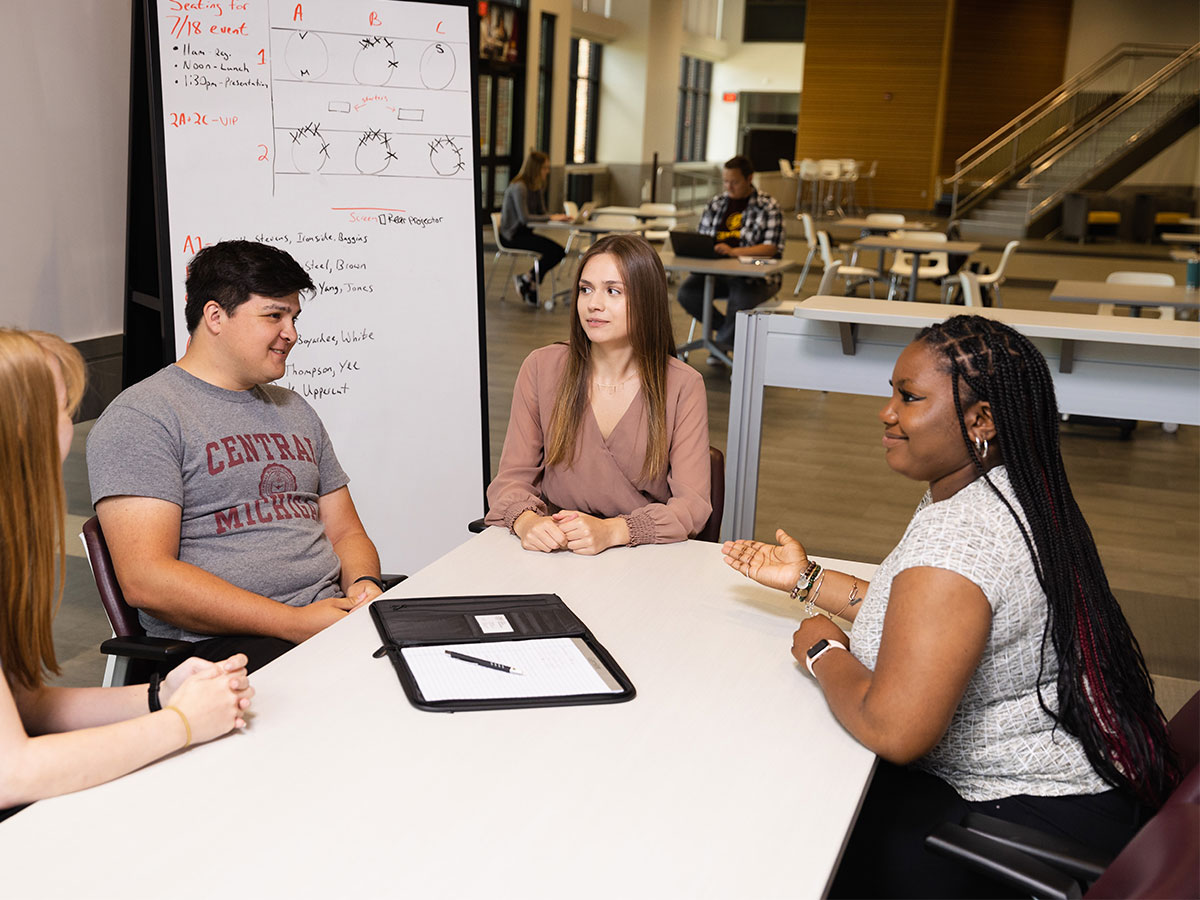 a diverse group of students discussing academic work at central michigan university