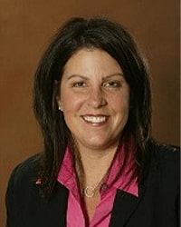 Darlene Nowak-Baker is an Alumni Board member who holds Emeritus status and she has shoulder-length black hair and is wearing a black blazer and pink button-down shirt.