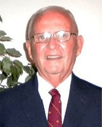 Ron Kevern is an Alumni Board member who holds Emeritus status and he is wearing a navy suit with a maroon and gold tie and glasses.