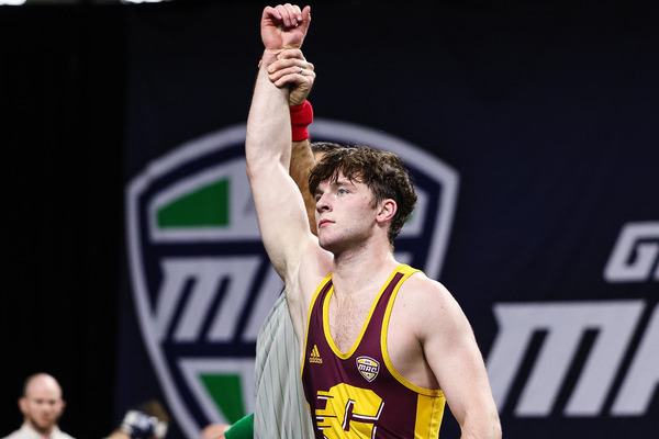 CMU wrestler getting hand raised after winning match.