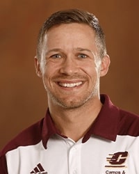 Scott George's headshot for the Alumni Awards while wearing a CMU maroon and white polo and smiling with teeth with short blonde hair.