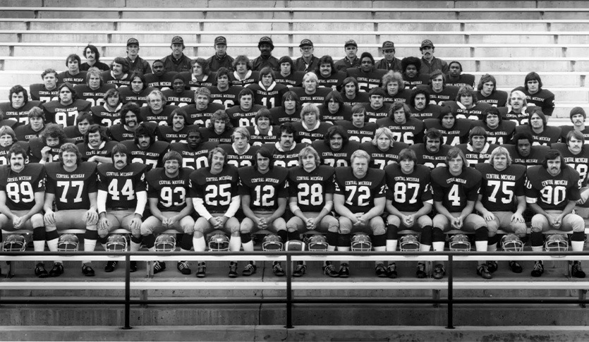 A black and white photo with the full 1974 CMU Chippewa Football Team. They are seated in rows on bleachers.